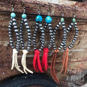 May include: Four pairs of silver bead earrings with turquoise accents and leather tassels. The tassels are white, red, brown, and orange.