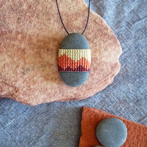 Handmade carved rock pendant with woven seed bead inlay