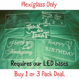 May include: Five clear acrylic signs with various holiday and celebratory messages, including "Happy Easter", "Trick or Treat", "Happy Thanksgiving", "Happy Birthday", and "Merry Christmas". The signs are on a green surface and the text is "Plexiglass Only" and "Requires our LED bases Buy 1 or 3 Pack Deal."