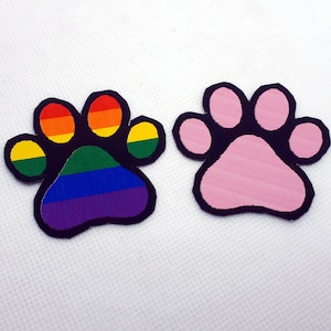 May include: Two paw print patches, one with a rainbow design and the other pink.