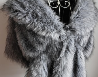 May include: A grey and white faux fur stole draped over a white wire mannequin. The long, thick, textured faux fur features a gradient of dark grey and white tones throughout the piece. The text Anna Party supply is visible at the bottom.