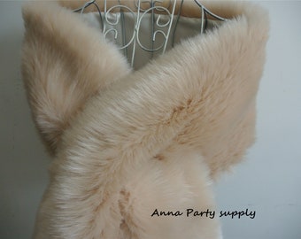 May include: A light beige faux fur shawl. The shawl is draped over a mannequin and is made of soft, fluffy fur.