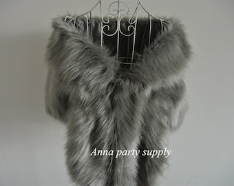 Peut inclure: Un châle en fausse fourrure gris drapé sur un mannequin blanc. Le châle est doux et moelleux, et il serait parfait pour un mariage ou une autre occasion spéciale. Le texte "Anna party supply" est visible en bas de l'image.