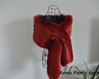 Könnte beinhalten: Ein roter Kunstfellschal, der über eine schwarze Schaufensterpuppe gelegt wird. Der Schal ist weich und flauschig und wäre eine großartige Ergänzung für jede Wintergarderobe.