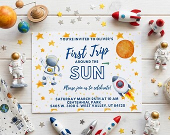 May include: A rectangular invitation card featuring a space theme with yellow stars, a watercolor planet, and a rocket. The text reads: You're invited to Oliver's First Trip Around the Sun. Please join us to celebrate! Saturday March 25th at 10 AM.