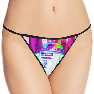 May include: White thong underwear with a black trim and a colorful graphic of the Star Wars character R2-D2. The graphic has a rainbow-colored dome and a purple and pink background.