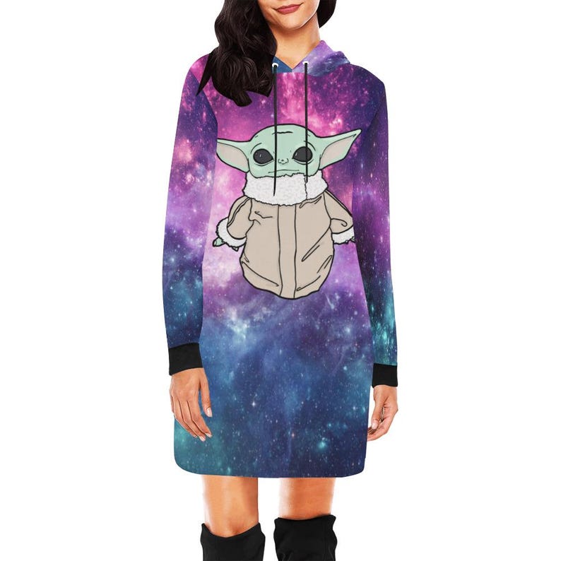 Puede incluir: Vestido con capucha de manga larga con estampado de galaxia en morado, azul y rosa. El vestido presenta un personaje de dibujos animados con orejas grandes y un abrigo beige. Las mangas tienen pu&ntilde;os negros.