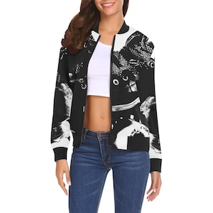 May include: Black and white bomber jacket featuring a repeating pattern of sneakers. The jacket has a classic bomber style with a black collar, cuffs, and hem. The design is a bold, graphic statement.