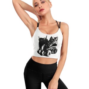 May include: White crop top with black spaghetti straps featuring a black and white graphic of roller skates. The top is a scoop neck style and is made of a soft material.