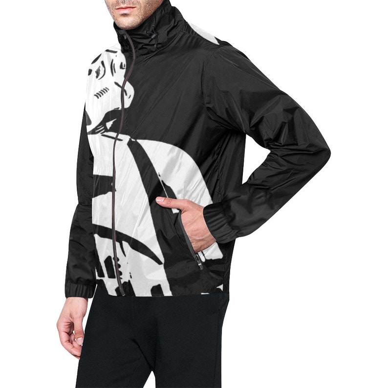 May include: Black and white windbreaker jacket with a full-length zipper and a high collar. The jacket features a bold, abstract design on the front and upper back. The design is primarily white with black accents. The jacket has two side pockets.