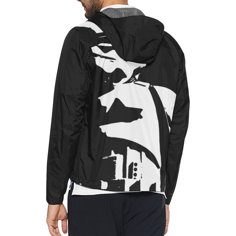 May include: Black hooded jacket with a white abstract design on the back. The jacket has a full-length zipper and a white lining. The jacket is made of a lightweight material and has a drawstring hood.