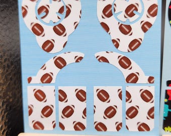 May include: A set of blue and white vinyl decals featuring a football pattern. The decals are designed to fit a controller.
