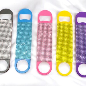 May include: Five bottle openers with a rhinestone design. The bottle openers are in the colors black, blue, pink, yellow, and purple.