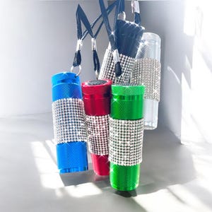 May include: Five small flashlights covered in rhinestones. The flashlights are blue, red, green, silver, and black.