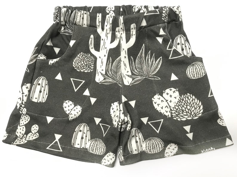 May include: Gray shorts with a white cactus and triangle pattern.
