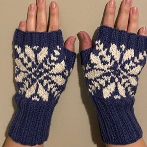 May include: A pair of blue fingerless gloves with a white snowflake pattern.