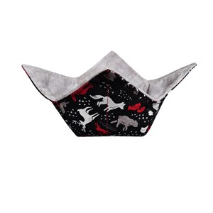 May include: A black fabric bowl with a white and red woodland animal print. The bowl is lined with gray fabric and is folded up.