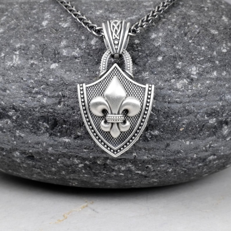 Fleur De Lis Knot Necklace with Spiga Neck Chain, Shield Shape Pendant with Classic Hook Attached to the Frame, the Final Look of the Pendant is Matte Frame and the fleur de lis is Silver Matte