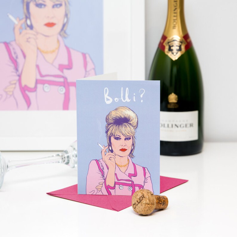 Peut inclure: Une carte de v&oelig;ux illustrant une femme de dessin anim&eacute; avec des cheveux blonds et une veste rose. Le texte sur la carte est "Bollo?"