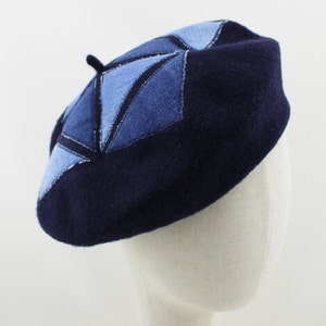 Op de afbeelding: Een marineblauwe baret met een geometrisch ontwerp gemaakt van blauwe denim patches.