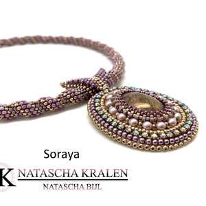 May include: A beaded necklace with a large, oval pendant featuring a brown stone surrounded by smaller beads in shades of purple, gold, and iridescent white. The necklace is made with a twisted rope design and is labelled "Soraya" and "NATASCHA KRALEN NATASCHA BIJL".