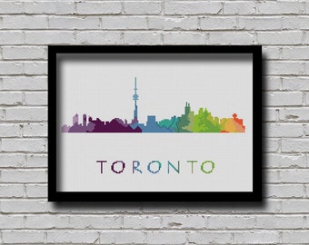 Könnte beinhalten: Ein gerahmtes Kreuzstich-Design der Skyline von Toronto in einem Regenbogen aus Farben. Der Text "TORONTO" befindet sich unterhalb der Skyline.