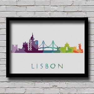 Op de afbeelding: Een kleurrijke gepixelde skyline van Lissabon, Portugal. De skyline toont een verscheidenheid aan gebouwen, waaronder een hoge toren, een brug en een kerk. De naam van de stad "LISBON" staat in wit onder de skyline.