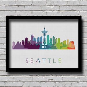 May include: A colorful pixelated illustration of the Seattle skyline, including the Space Needle, with the word "SEATTLE" written below.