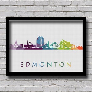 Op de afbeelding: Een kleurrijk pixel art stadsbeeld van Edmonton, Alberta, Canada. De skyline toont verschillende gebouwen, waaronder de High Level Bridge, het Shaw Conference Centre en het parlementsgebouw. De naam van de stad staat in een regenboogkleurig lettertype onder de skyline.