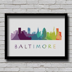 May include: A colorful pixelated skyline of Baltimore, Maryland, with the city name written below in a rainbow of colors.