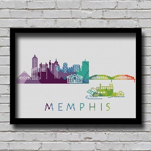 May include: A colorful cross-stitch design of the Memphis skyline, featuring buildings, a bridge, and a riverboat. The text "MEMPHIS" is stitched below the skyline.