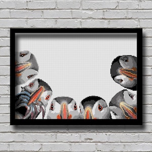 May include: A framed print of a group of puffins peeking out from behind a white background. The puffins are arranged in a semi-circle, with their heads and beaks visible. The print is in black and white.