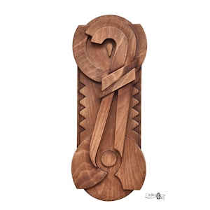 Può includere: Una scultura da parete in legno con forme astratte e una finitura marrone. La scultura è realizzata con più pezzi di legno che si uniscono per creare un design unico.