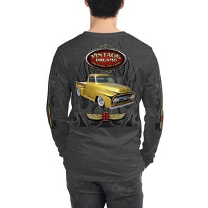 May include: A long-sleeved grey t-shirt with a vintage truck graphic on the back. The truck is gold with red accents and is surrounded by flames. The text "Vintage Dreams" is in a red oval above the truck. The text "Custom Hot Rods - Parts & Service" is in a smaller font below the truck.