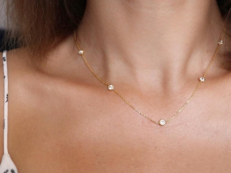 Diamond station necklace worn around the neck, showcasing the elegant design and how the CZ diamonds sparkle when worn.