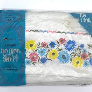 May include: A white no-iron muslin sheet with a floral border in shades of pink, blue, yellow, and green. The sheet is packaged in plastic and labeled "No Iron Muslin Sheet" and "Gun Home". The sheet is designed to fit a 54 x 76 inch mattress.