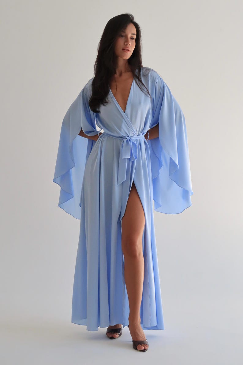 The model is wearing a long flowing silk robe with long wide sleeves.