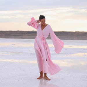 The model is wearing a long flowing silk robe with long wide sleeves.