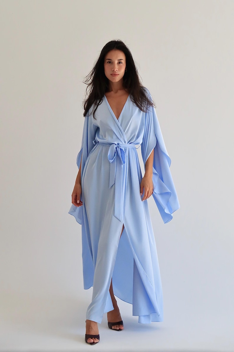 The model is wearing a long flowing silk robe with long wide sleeves.