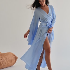 The model is wearing a long flowing silk robe with long wide sleeves.