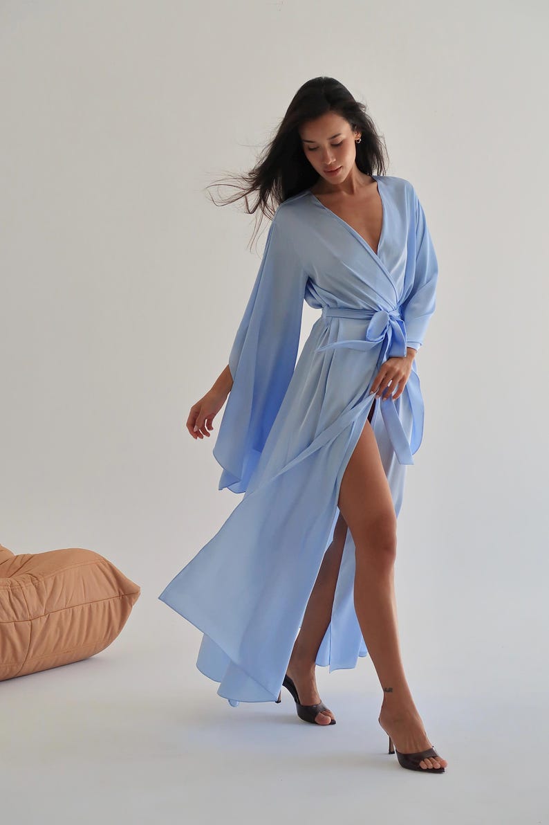 The model is wearing a long flowing silk robe with long wide sleeves.