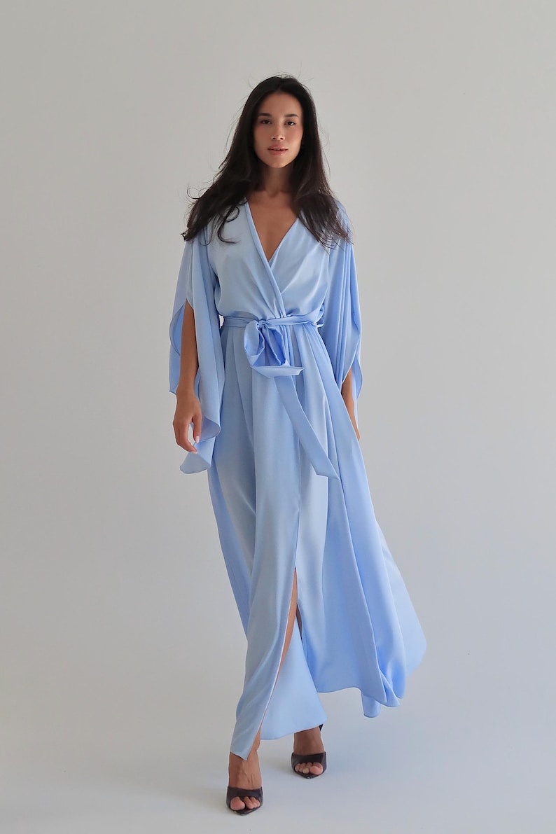 The model is wearing a long flowing silk robe with long wide sleeves.
