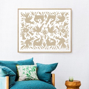 Op de afbeelding: Een ingelijst drukwerk met een witte achtergrond en een bruin ontwerp van gestileerde vogels, konijnen en bloemen. De print hangt aan een witte muur met een klein bruin stippenpatroon.
