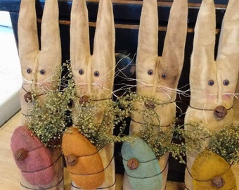 Primitive stick bunnies there ten inches tall by 2 inches wide it's wrapped with Sweet Annie and has I felt wool egg