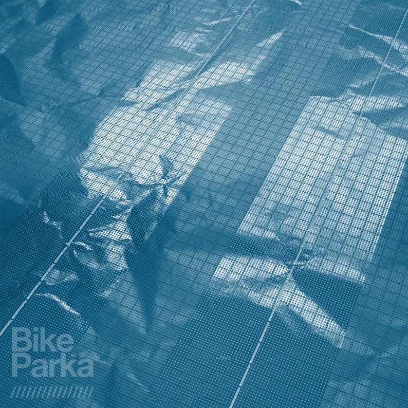 May include: Blue-toned image with a grid pattern overlaying a textured surface. The words "Bike Parka" are visible in the lower left corner. The overall effect suggests a product designed for bicycle protection.