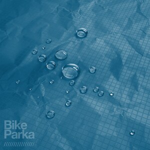 May include: Close-up of a teal blue, water-resistant fabric with several water droplets on the surface. The fabric has a grid-like pattern. The words "Bike Parka" are printed in white on the lower left.