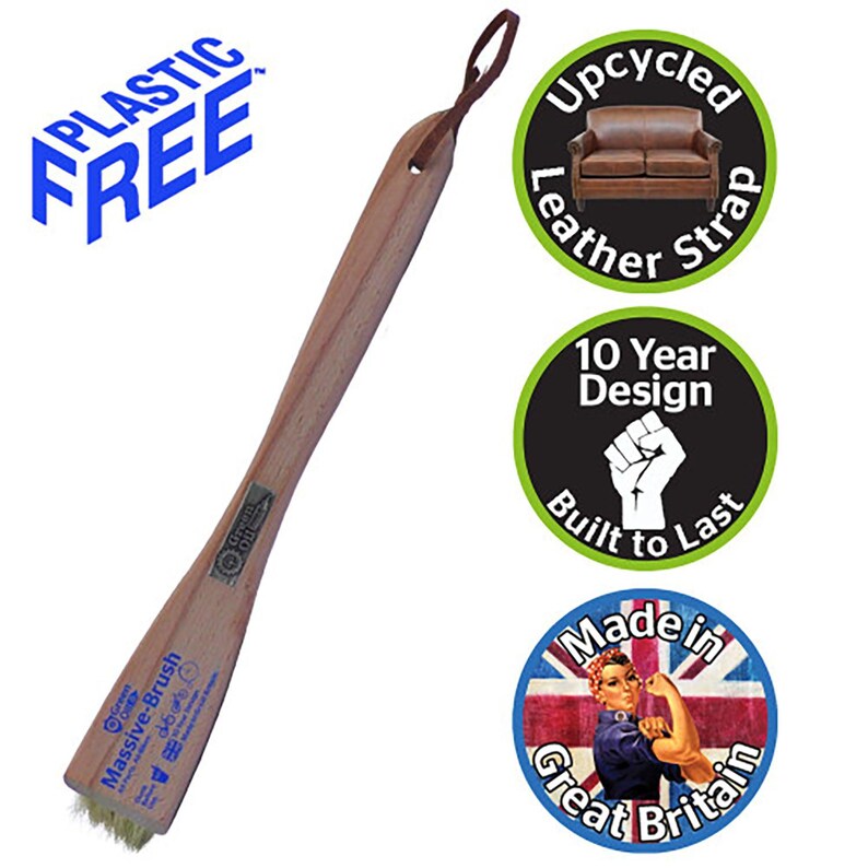 Puede incluir: Un cepillo de zapatos de madera con mango marr&oacute;n claro y cabezal de cepillo. El cepillo tiene una correa de cuero para colgarlo. El texto en el cepillo dice "Massive-Brush". El texto adicional incluye "Plastic Free", "Upcycled Leather Strap", "10 Year Design Built to Last" y "Made in Great Britain".