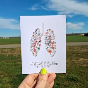 May include: A watercolor illustration of a pair of lungs with flowers growing from them. The text "THE SPIRIT OF GOD HAS MADE ME & THE BREATH OF THE ALMIGHTY GIVES ME LIFE" is written below the image. The text "JOB 33:4" is written below the quote.