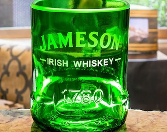 May include: A green glass tumbler with the Jameson Irish Whiskey logo and the year 1780 printed on the side. The glass has a rounded base and a straight rim.