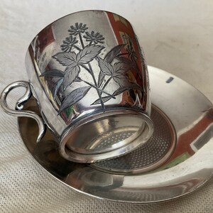 Simpson, Hall, Miller Taza de té y platillo de metal grabado con plato cuádruple, 1889